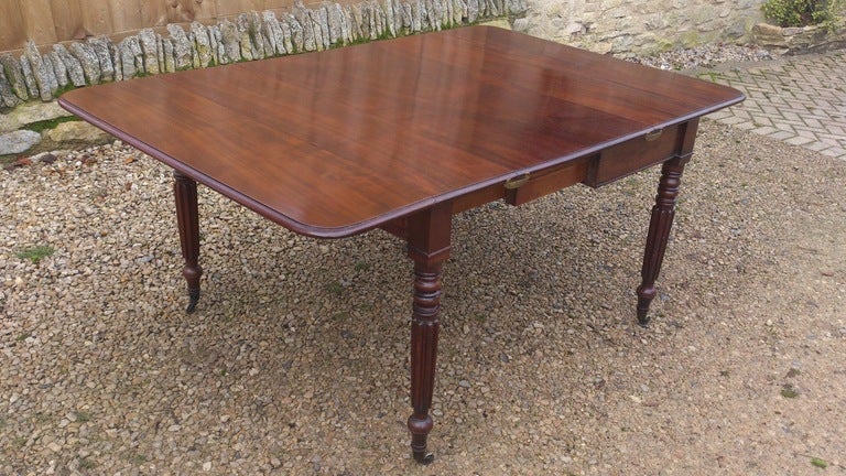 An unusual and versatile extending Pembroke table with removable leaf. The legs are especially slender and the frieze narrow on the early 19th century tables like this. It is made of good interesting dense grained mahogany and is a very solid and