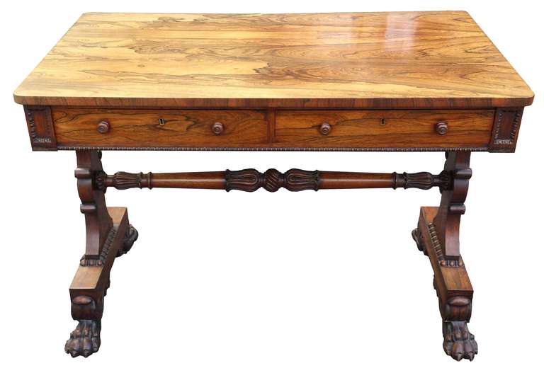 Antique side table or library table with drawers one side and false drawers the other, made of rosewood that has faded in such a way as to emphasise the patterns in the wood grain. It has mahogany lined drawers and there are casters recessed into