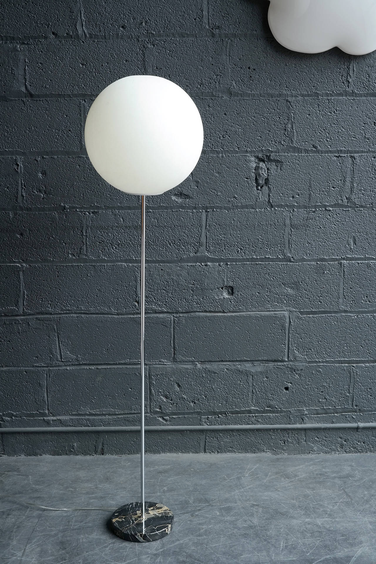 Lightweight plastic sphere emits a warm glow and is supported by a thin chrome-plated shaft weighted by an 8.5