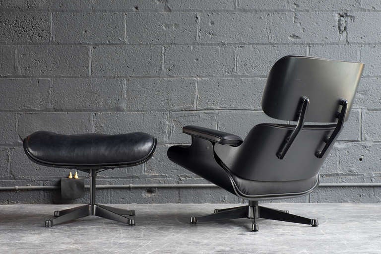 Here we have an authorized original manufactured in Italy by ICF under license from Herman Miller.

Original black leather upholstery, black bent plywood frame, and black metal base/back brackets.

The seat & ottoman are down/feather blended.