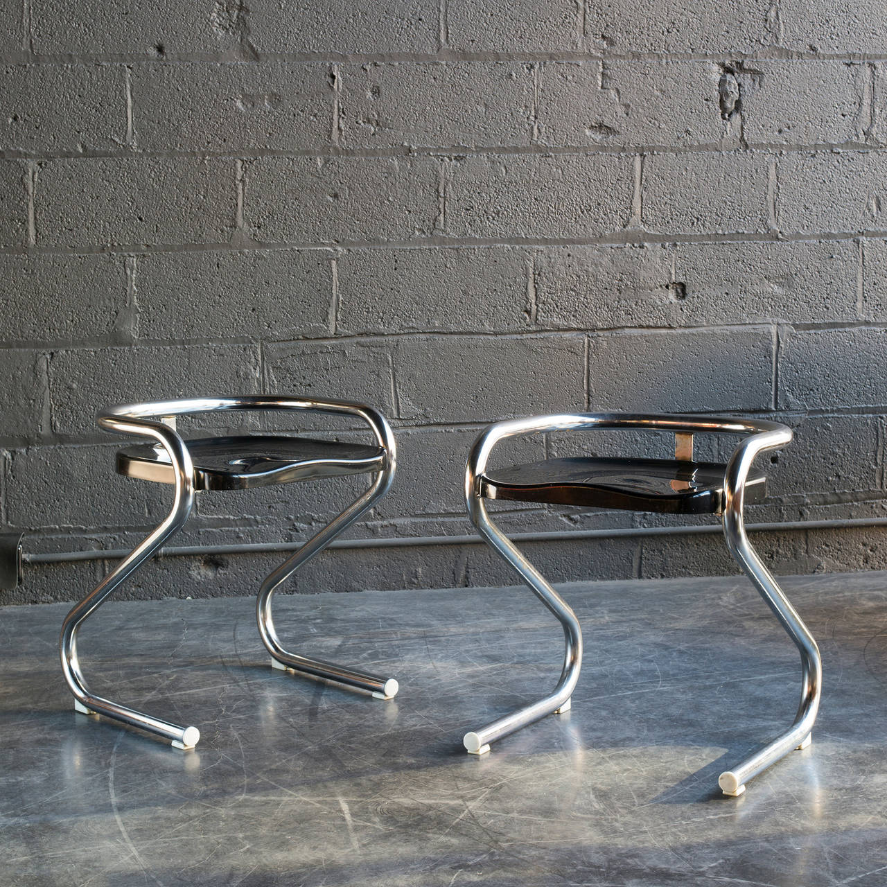 Sinuous, tubular chrome frame. Molded black plastic seat and original plastic feet.