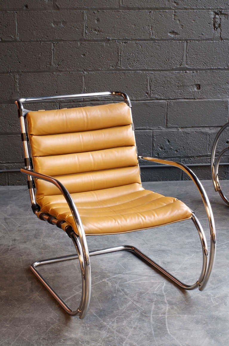*Please note one chair has been sold; one chair is available*

cantilevered, stainless steel frame;
contrasting, black leather support straps;
padded, tan leather cushions with hand-stitched closure