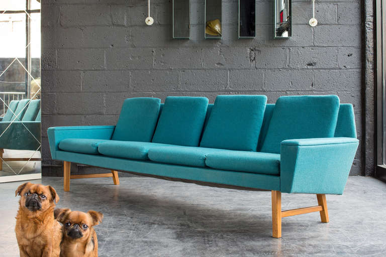 A handsome and comfortable sofa with the original greenish blue wool fabric in fine condition with minor signs of wear. Elevated on light teak legs.