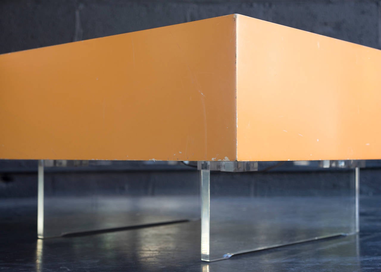 Nicely proportioned as a coffee table, end table, or pedestal. Wood light box with original pale orange finish fitted with LED interior lights. White acrylic top. Raised on Lucite panels.