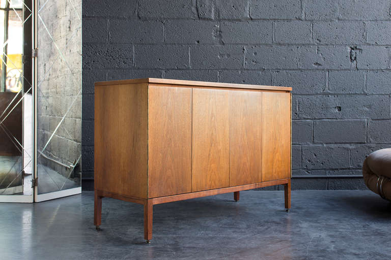 Original oiled walnut finish, book matched doors on piano hinges, five drawers, one adjustable shelf, presentable from every angle. Manufactured by Calvin Furniture.