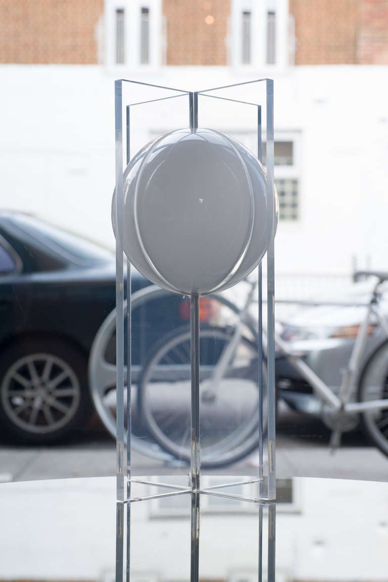 a white sphere is suspended amid 2 intersecting planes