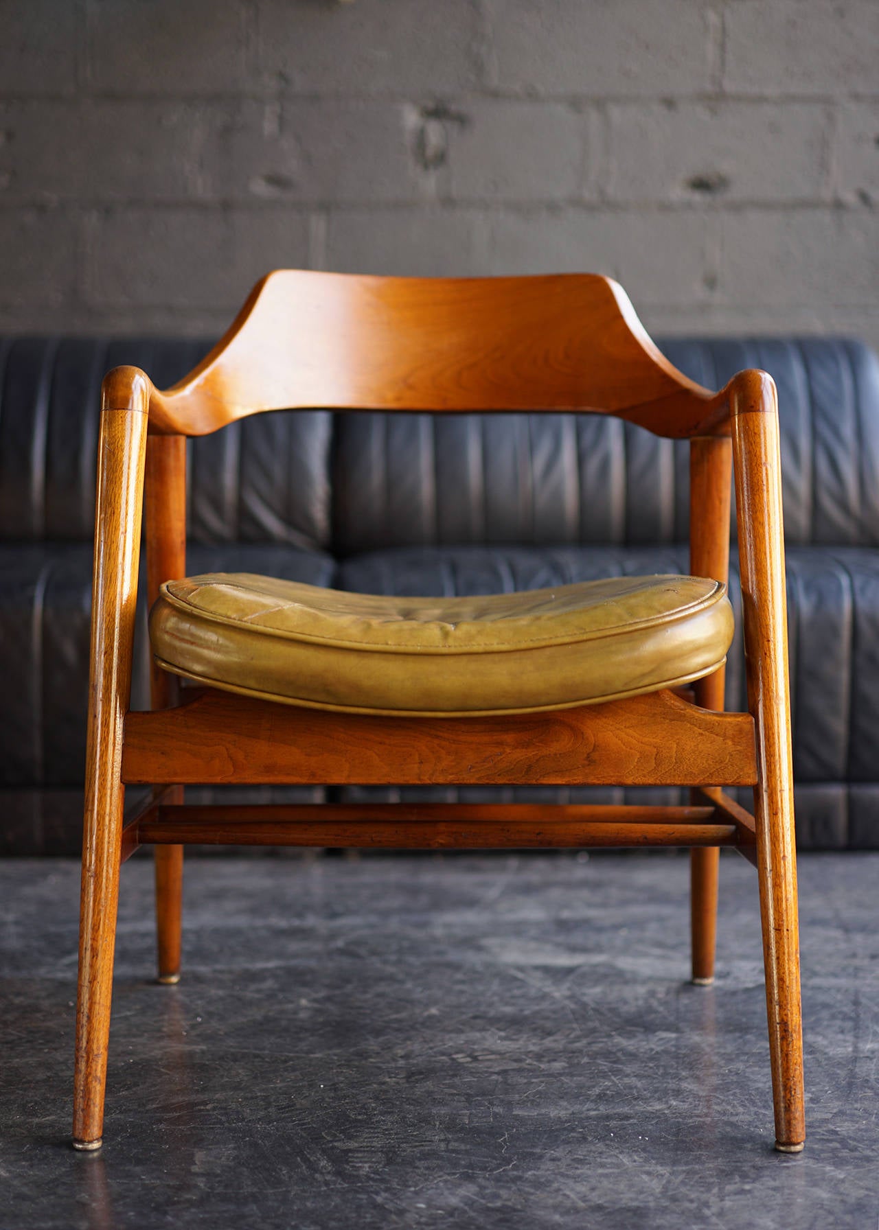 Sturdy, handsome, and sculptural solid wood frames. Original leather upholstered seats. Lower shelf storage. Originally commissioned for the offices of  Colgate-Palmolive, with numbered corporate badges underneath.
