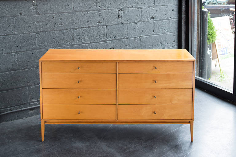 Handsome and in very good condition with original finish on solid maple construction, original unpolished brass hardware, eight drawers, and original Paul McCobb label.