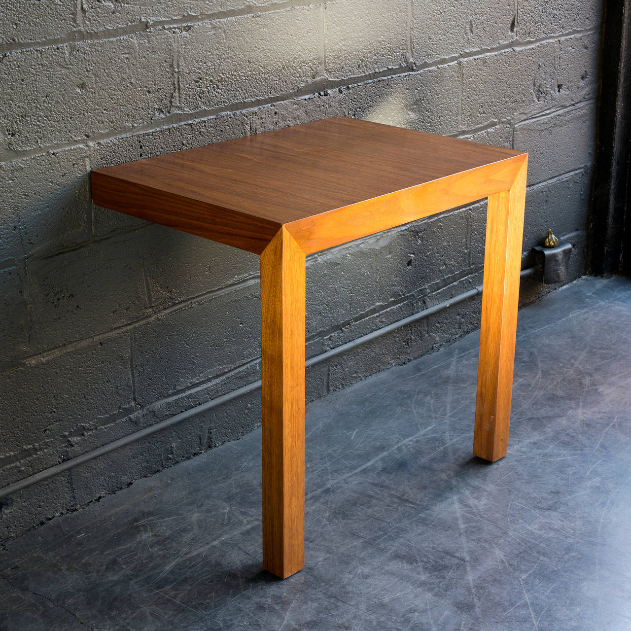 This clever walnut table appears to be emerging out of the wall.