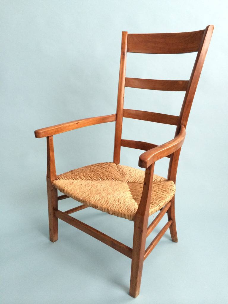 Tall back armchair with rattan seat.