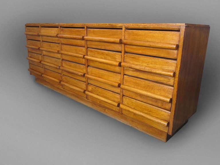 A French modernist chest of drawers. Includes 20 drawers with cylinder shaped pulls.