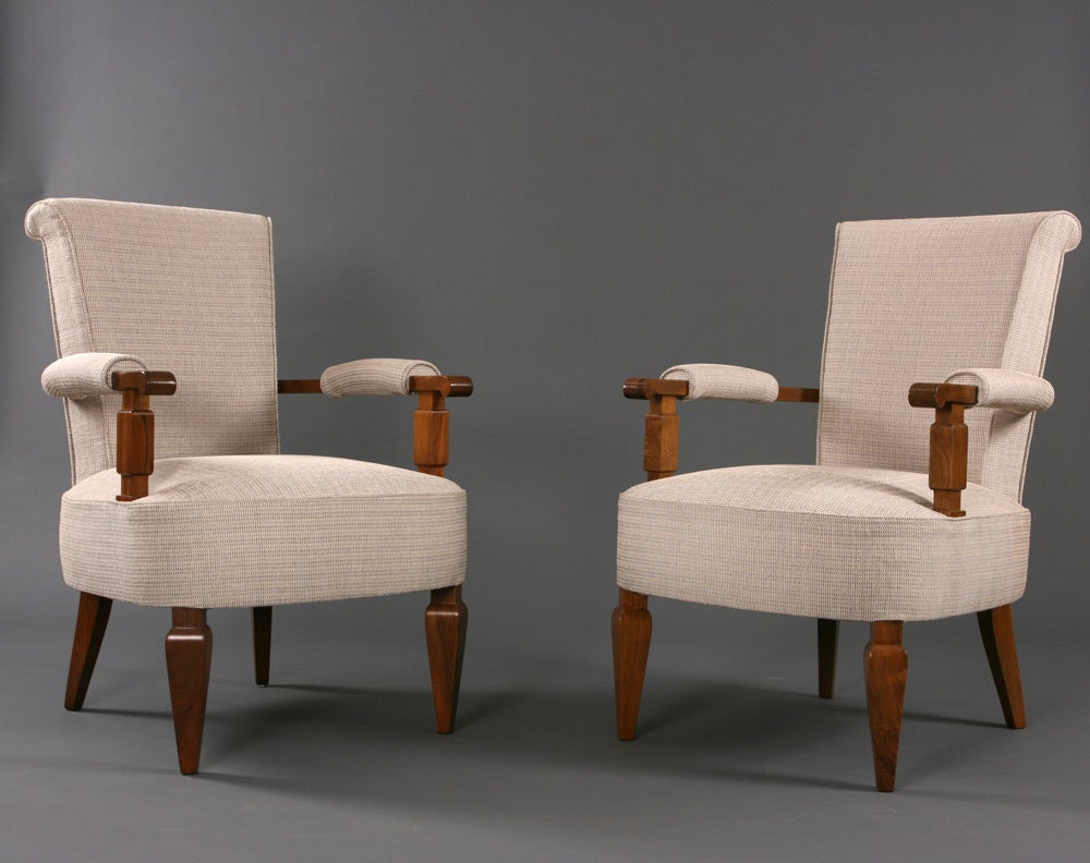 A rare neoclassical pair of Jules Leleu armchairs in French walnut.