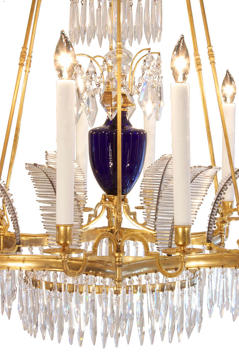A stunning Russian mid 19th century Neo-Classical st. crystal and ormolu twelve light chandelier. At the bottom is a circular ormolu gallery within a six sided concave shaped ormolu gallery, from which extend six pairs of scrolled arms, all