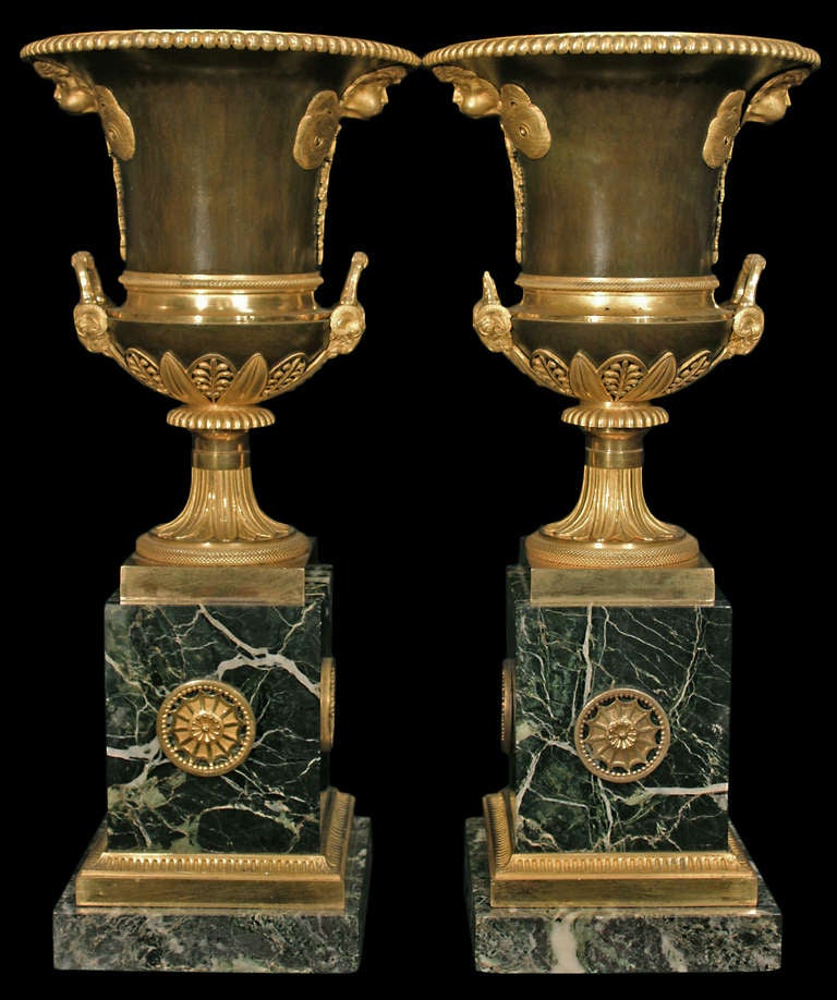 A very high quality pair of French 1st Empire period circa 1805-1810 patinated bronze, ormolu and Vert Patricia marble urns. Each urn is raised by a square marble base below a reeded ormolu band. The plinth decorated by side and front pierced ormolu