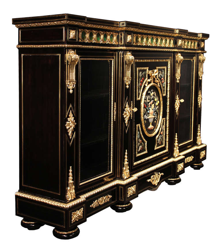 A spectacular French 19th century Napoleon III period Boulle ebony cabinet vitrine with ormolu and Pietra Dura mounts. This impressive cabinet is raised on six bun feet with ormolu bands. At the straight and scalloped frieze are striking foliate