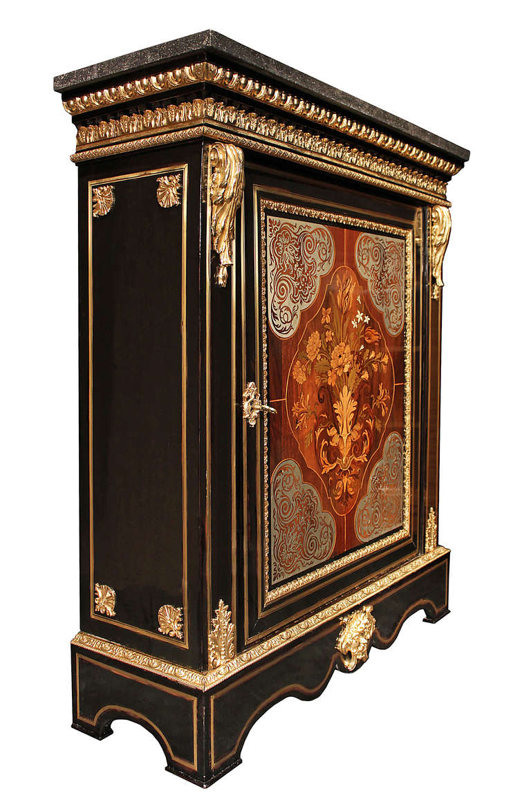 A handsome and statement making French mid 19th century Louis XIV st. Boulle cabinet. The cabinet is raised by a scalloped base with brass fillet inlay and centered by a fine ormolu mount of a mask and seashell. Above is a finely chased ormolu band