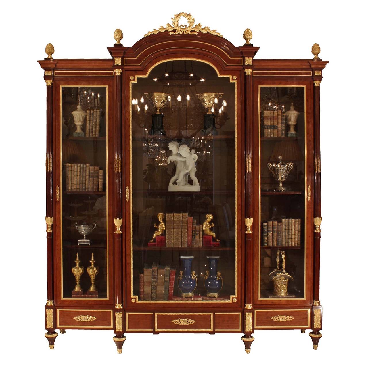 A magnificent French 19th century Louis XVI style mouchette mahogany and ormolu vitrine, signed Maison Millet. The cabinet is raised on four front and two back toupie shaped feet with ormolu sabots and top caps. The recessed paneled frieze is