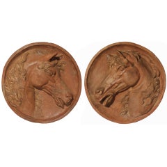 A pair of early 19th century Italian terra cotta stallion reliefs