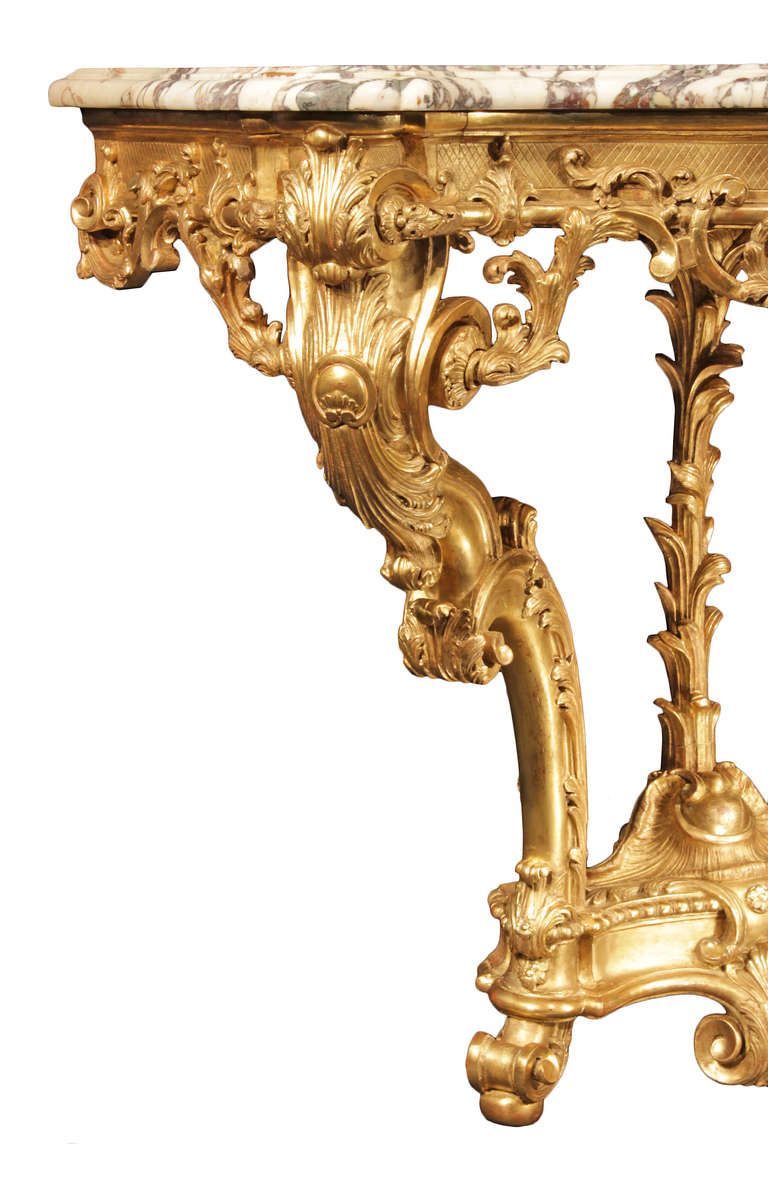 A spectacular French early 19th Régence st. giltwood console. This extremely elegant console is raised on three scrolled supports with carved foliate patterns. The arbalette shaped bottom pediment has a beaded edge and is centered by a decorative