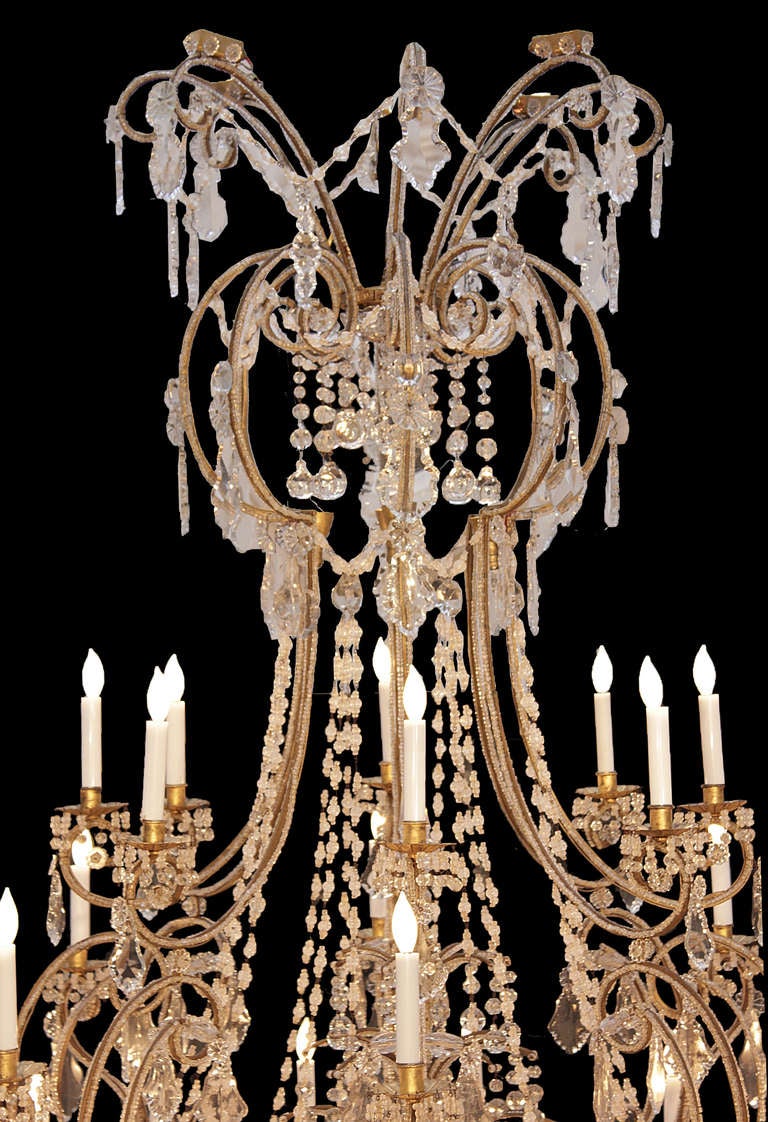 A most elegant and grand scale Italian early 18th century Baroque crystal -mounted gilt-iron open cage Turin chandelier with over 32 lights throughout. The chandelier with a 'C' scrolled design with various levels of electrified arms also has