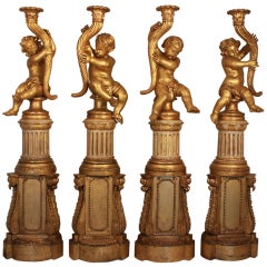 A set of four Italian patinated and gilt cherub Torchieres 9