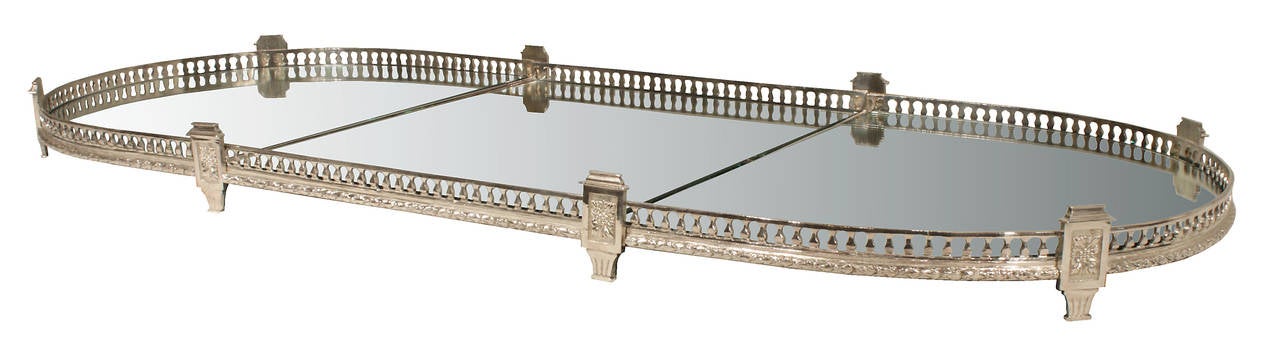 A grand scale and very elegant French mid 19th century Louis XVI st. silvered bronze three piece mirrored centerpiece. The centerpiece is raised by reeded supports, with a rectangular plaque displaying a flower and capital on each side, between the