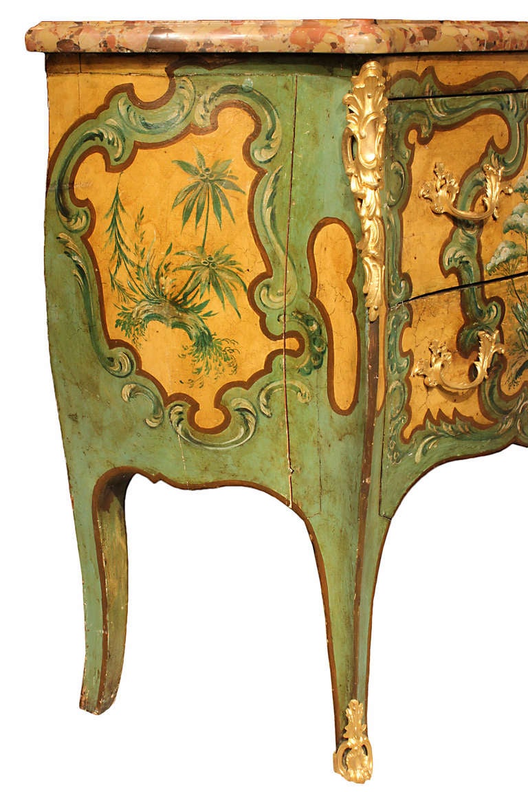 A very elegant and extremely decorative French mid 19th century Louis XV st. painted commode. The bombée shaped commode is raised on cabriole legs with wrap around ormolu sabots. The two drawers Sans Traverse, without crossbar, have an amber