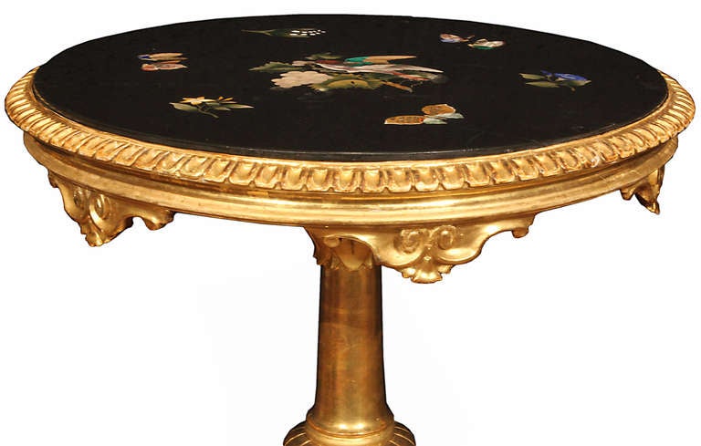 A sensational and very high quality Italian early 19th century giltwood and Pietra Dura Florentine side table. The circular table is raised on an S scrolled tripod base below the turned fut with carved designs of leaves. Above is the scalloped