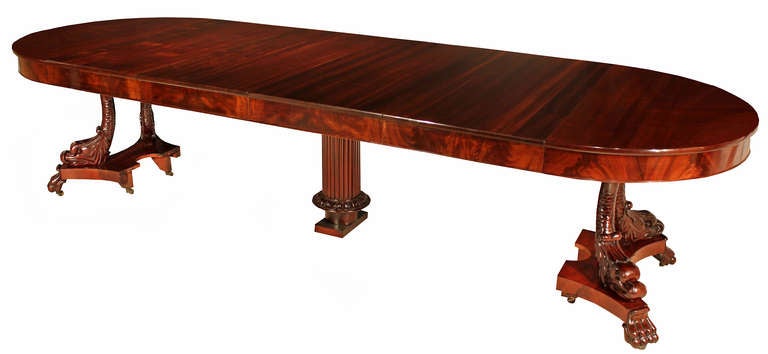 A spectacular and high quality Italian 19th century Neo-Classical st. mahogany dining table with six extensions. The table is raised on an attractive crotch mahogany concave sided tier on pawed supports above the original casters. With a central