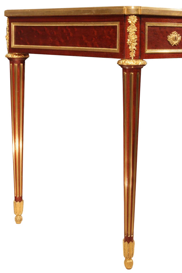 A handsome and extremely high quality French late 19th century Louis XVI st. mahogany, brass and ormolu mounted bureau plat signed by G. Durand. The bureau is raised by four circular fluted tapered legs with brass filets decorating the flutes. The
