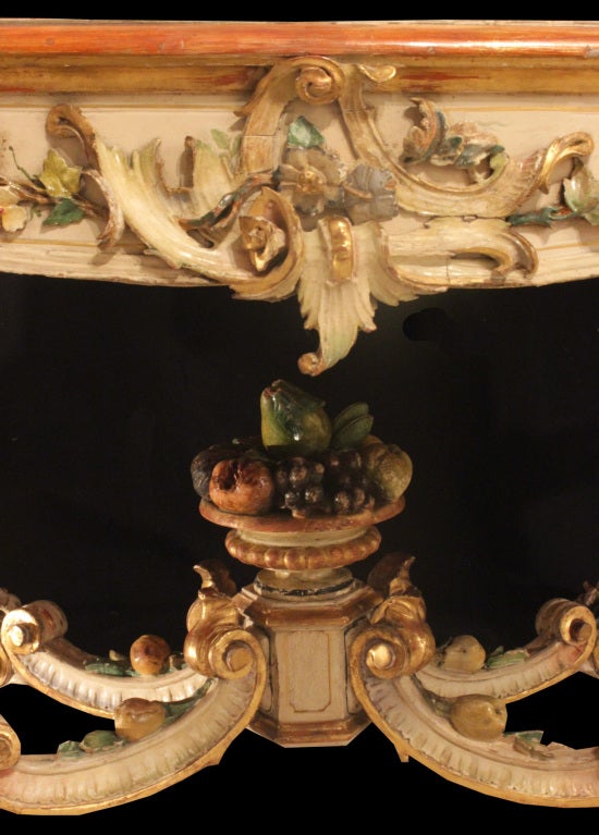 An exceptional early 19th century Italian center table with all original polychrome with vibrant pastel colors throughout. The table is raised by cabriole legs with intricate carvings of foliage. The legs are joined by an ‘X’ stretcher with a