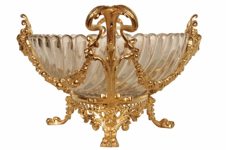 A stunning French 19th century Louis XVI st. Baccarat crystal and ormolu centerpiece. The centerpiece is raised on four ormolu paw feet below a scrolled foliate and richly chased pierced ormolu base. On each side of the Baccarat bowl, is a finely