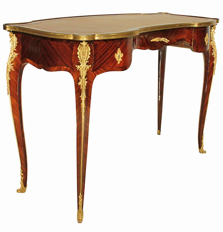 An extremely elegant French 19th century Louis XV st. kingwood and ormolu mounted three drawer Bureau Plat, signed Soubrier. The unusual shaped desk  is raised by slender cabriole legs decorated by richly chased top ormolu foliate mounts above the