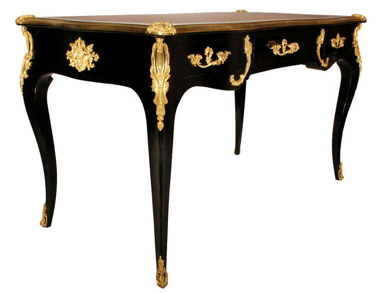A handsome French late 19th century ebony and ormolu mounted three drawer Bureau Plat, signed Rinke. This statement making Bureau is raised by four cabriole legs ending in scrolled, pierced ormolu sabots. Above the legs are finely chased ormolu