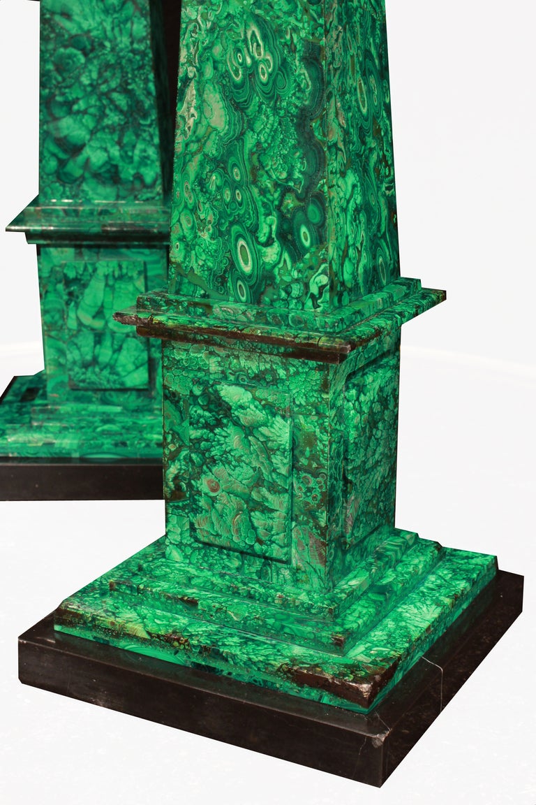 An impressive and very decorative pair of 19th century Italian  malachite obelisks. Each obelisk is raised on a square black Belgium marble support with a mottled border. Above the malachite stepped platform base supports the square plinth with