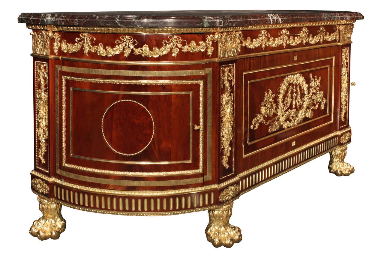 A spectacular and grand scale French Louis XVI style mid-19th century flamed mahogany and ormolu-mounted commode. The chest is raised by opulent lion pawed ormolu supports. The 'D' shaped frieze is elegantly decorated by ormolu fitted flutes all