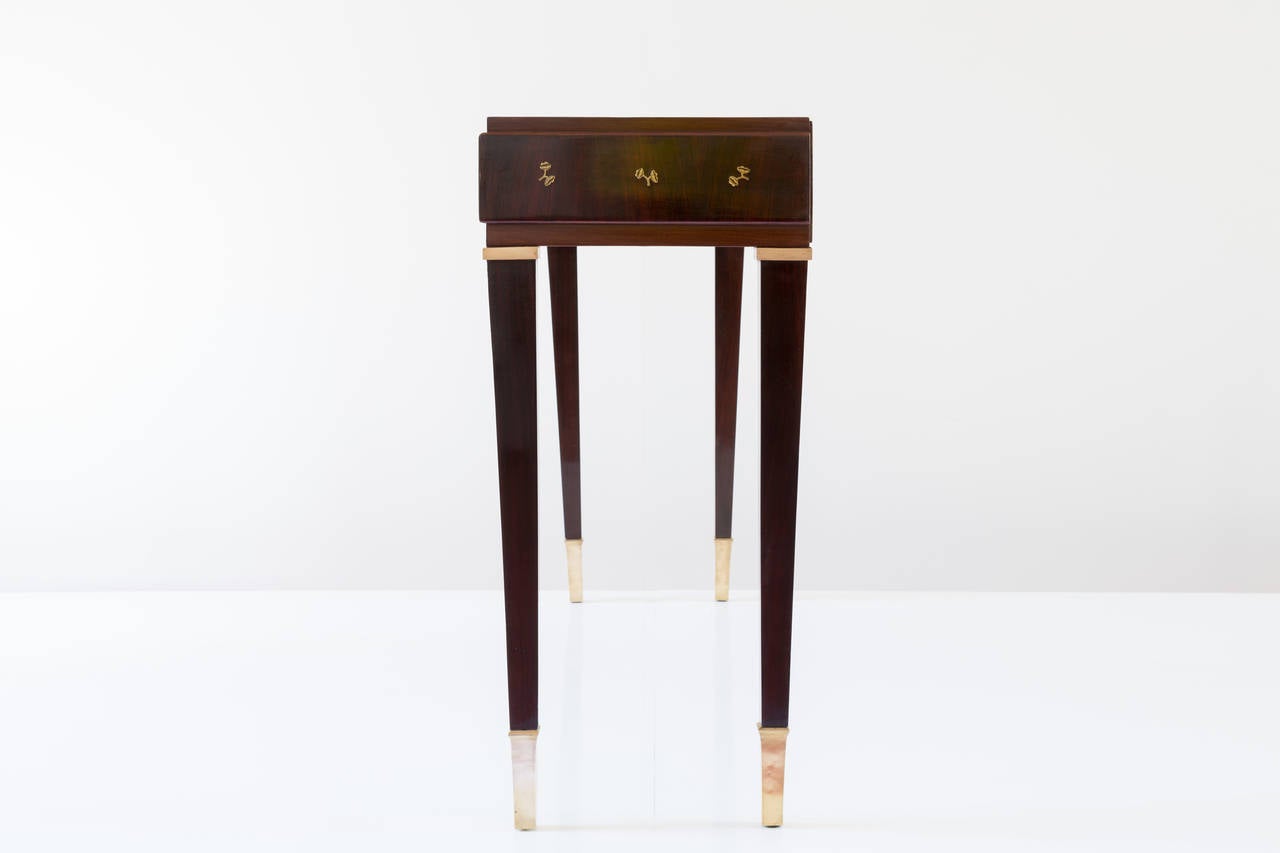 Grand console by Paolo Buffa. 
Produced by cabinetmakers Marelli & Colico, Cantù. 
Rosewood and brass.
Three drawers, brass details and brass feet
little flowers. 
Measures: H 90cm, 162 x 42 c, height heach drawer: 12 cm.
Very good