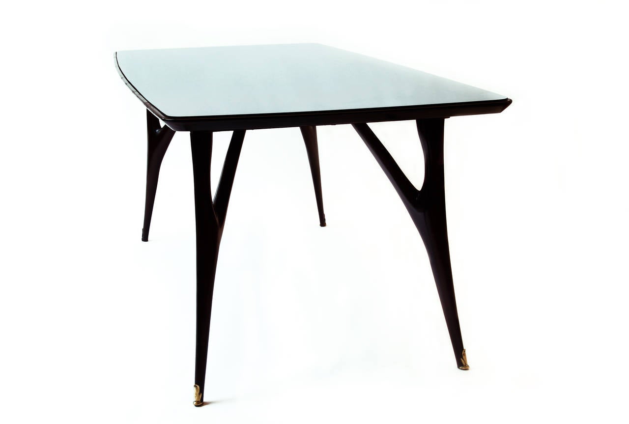 important italian dining table, 1950.
style Ico and Luisa Parisi 
exhecuted probably by Dassi, 1950 
Top in mirrored blue glass (replaced).
Ebonized rosewood, brass and mirrored glass.

Conditions: Very good condition.
Measures: H 81 cm; 194