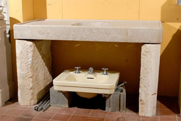 Classic 19th century large stone sink from Cassis, France, circa 1840.  This large Provencal stone slab has a center circular wash basin with a drain hole.  The legs are of cut French Limestone.