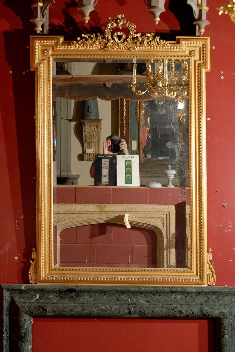 19th century French gilded trumeau with incredibly detailed wreath crest and original mirror glass, circa 1840.