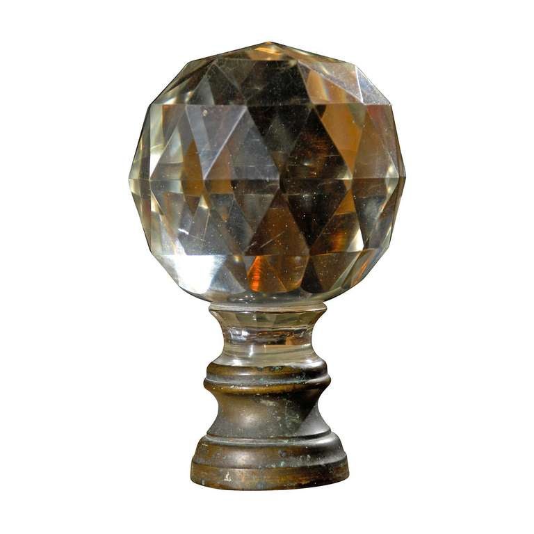 19th century French staircase finial with a faceted round glass ball mounted on a brass base,as shown. Boules d'escalier are typical as the terminal mounts on a descending staircase, normally wrought iron, in France. They historically are believed