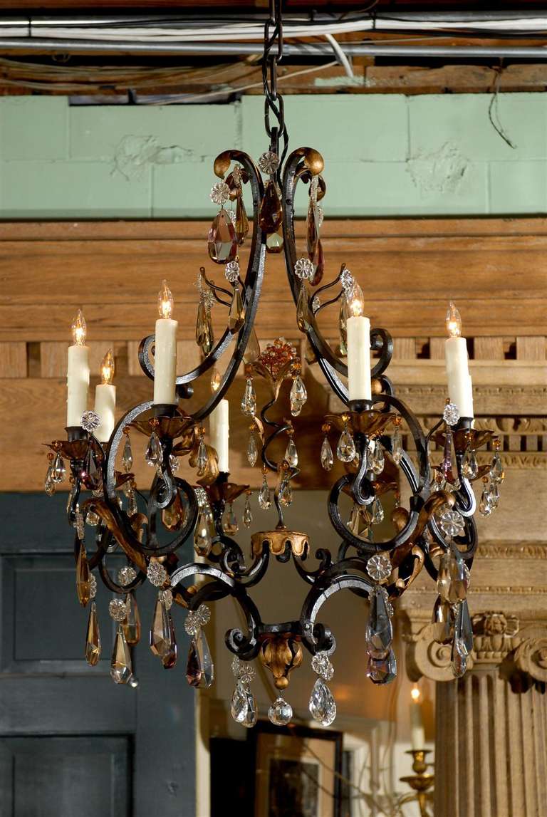 Lovely 19th century French iron & crystal chandelier with 8 lights with beeswax candle sleeve covers.  Gilded iron foliate accents.  Amathyst, amber, and clear crystals adorn this fixture.  Gilded iron canopy included. 

Fixture is UL Listed.