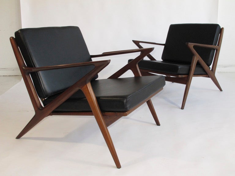 Pair of sculptural lounge chairs designed by Poul Jensen for Selig. New black leather cushions on walnut stained beech frame.