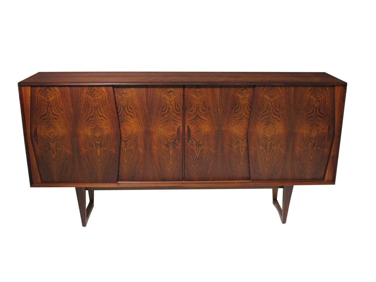 Mid-Century Brazilian Rosewood sideboard with dynamic book-matched grain on four sliding doors. Mahogany interior with adjustable shelves on right and left. Light automatically turns on when center doors open, to reveal a mirrored bar above three