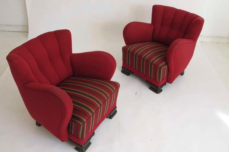 Pair of 1930's club chairs with shell back and dramatically sloped arms. Red wool fabric with olive green striped inner-spring seat cushion. High quality construction.