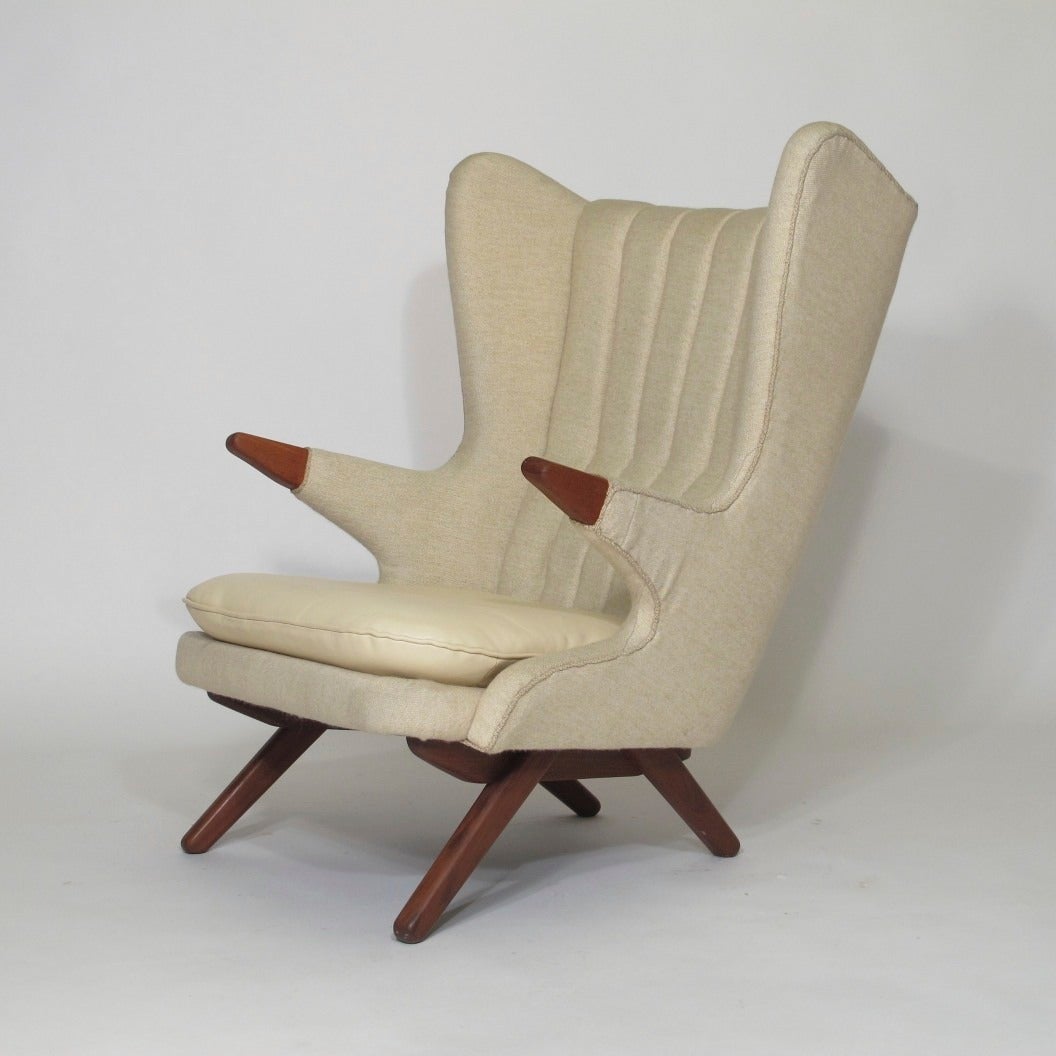Original Danish high back chair model #91 designed by Svend Skipper for Skipper Mobler. Features a solid hardwood frame with exposed teak arm rests, original off-white wool textile upholstery and beige leather seat cushion. 