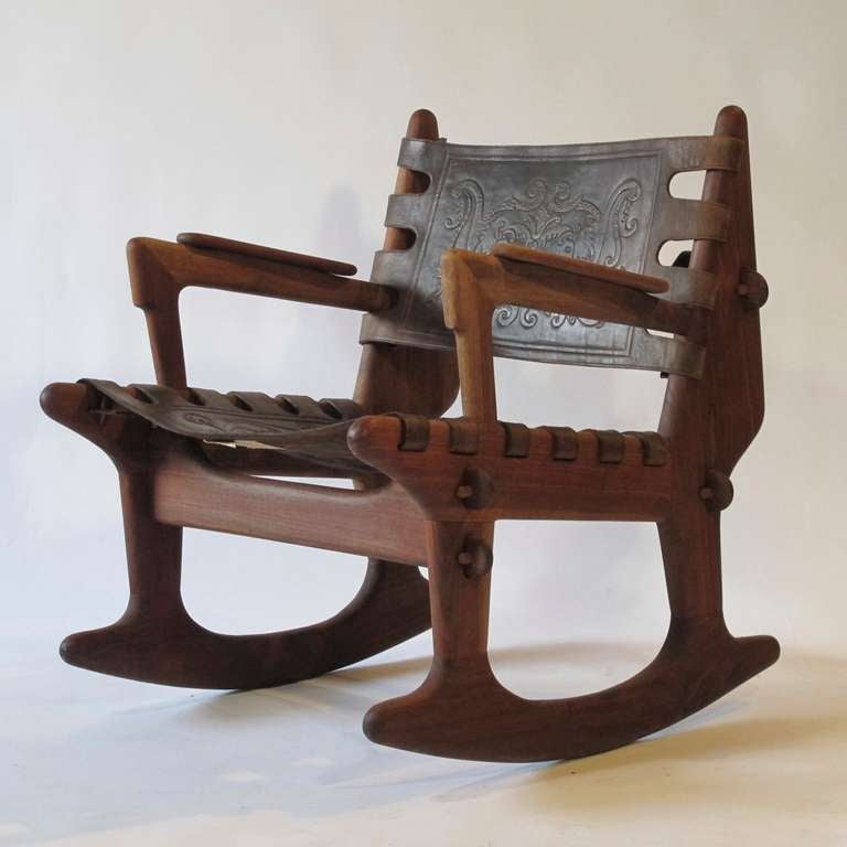 Wood framed rocking chair bearing the metal and cloth tag of Angel Pazmino, by Meubles de Estilo, Ecuador, solid wood frame with pegged construction, embossed leather seat and back depicting Incan figures, signed. 