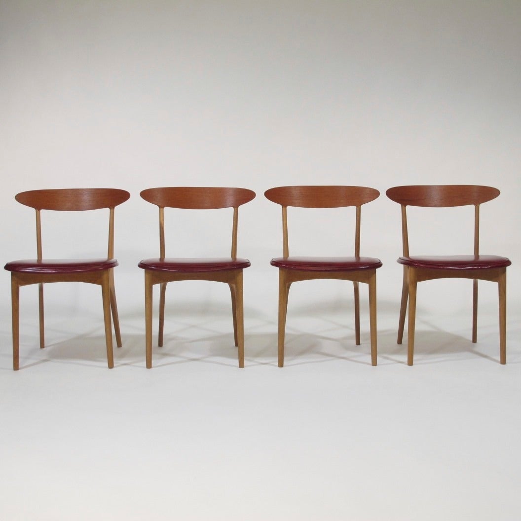 Four Danish dining chairs designed by Kurt Ostervig. Beautiful white oak frames with dramatic curved back with teak facing. Vintage burgundy vinyl seats. 

Kurt Ostervig rectangle dining table with draw leaves also available. 
Images available