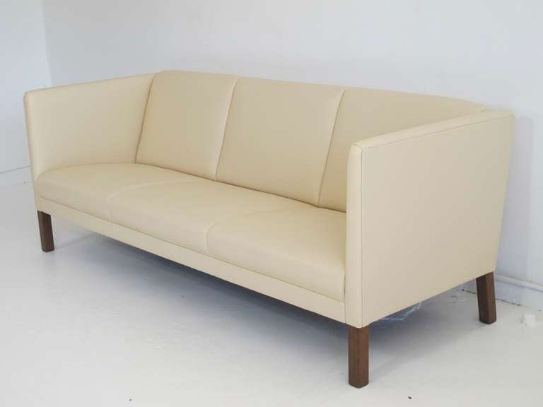 Danish three-person sofa in beautiful cream colored leather raised on a solid wood legs designed by Erik Jorgensen c.1972. Newly upholstered in soft high-quality leather.