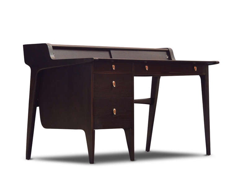 Mid-century Modern desk designed by John Van Koert for Drexel. Desk features an ebony finish with grey leather writing surface. Secretary compartments behind sliding panels, above a series of drawers with newly brass plated pulls.